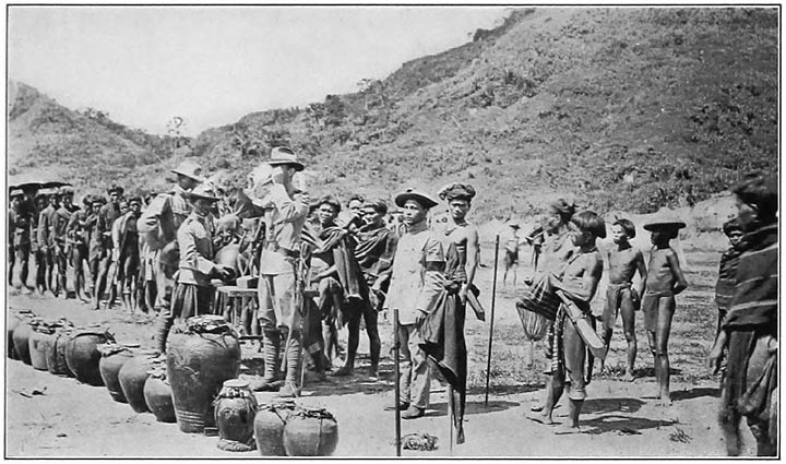 Fig. 1. Scene at a Kián͠gan celebration. Note the Chinese jars in the foreground. Those that Ban͠ggílît brought from the village of souls, in the Sky World, are of the type of the third jar from the left. (Photograph by Tomlinson.)