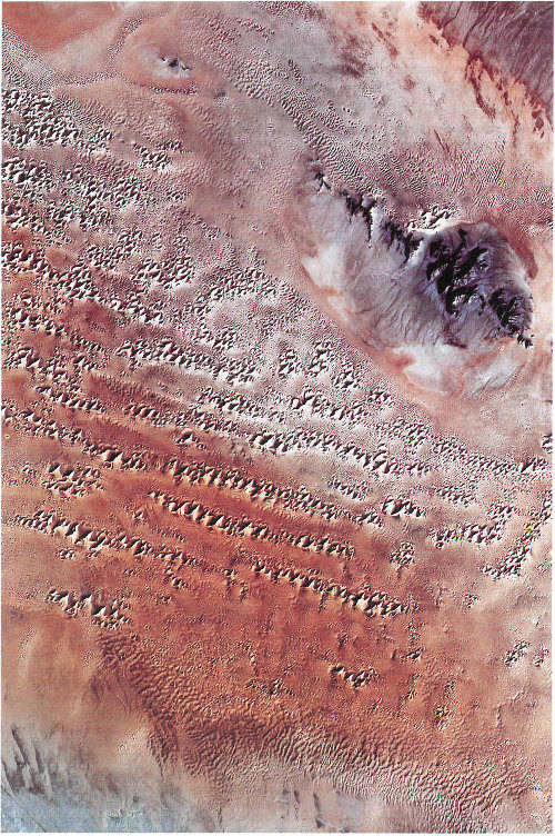 Gran Desierto of the Sonoran Desert, Mexico. Surrounding the dark 25-kilometer-long and 5-kilometer-wide Sierra del Rosario mountains (upper right) are dunes and sheets of sand.